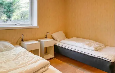 a small room with two beds and a window at Nice Home In Kverva With Wifi in Kverva