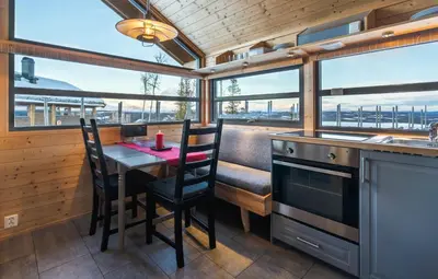 a kitchen with a table and chairs and windows at Liapark in Ål