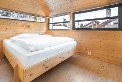 a large bed in a wooden room with windows at Liapark in Ål