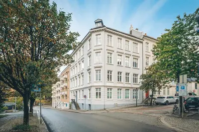 a white building on the side of a street at Rom i loftsleilighet med utsikt in Bergen