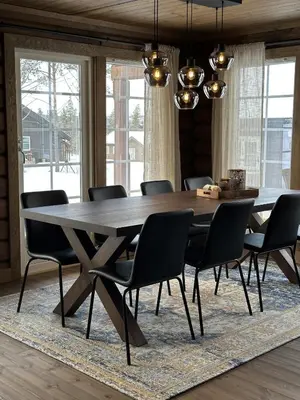 a dining room with a large wooden table and chairs at Sentrumsnær Røroshytte in Røros
