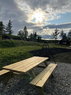 a wooden picnic table with a swing on it at Sentrumsnær Røroshytte in Røros
