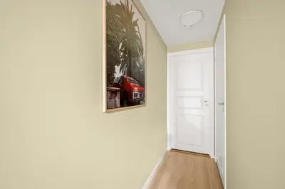 a hallway with a red car in a painting on the wall at Scandinavian Design in Authentic Nordnes in Bergen