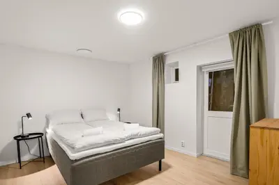 a living room with a bed and a window at Scandinavian Design in Authentic Nordnes in Bergen