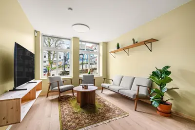 a living room with a couch and a tv at Scandinavian Design in Authentic Nordnes in Bergen