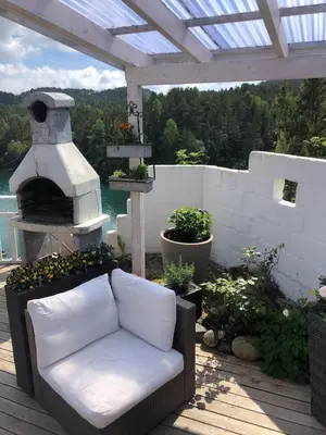 a couch sitting on a patio with a fountain at Stay where the mountains begin in Bømlo
