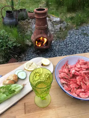 a table with a plate of food and a plate of meat at Stay where the mountains begin in Bømlo