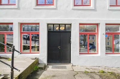 a black door on a white building with windows at BRAND NEW! Bergen Beds Apartments I Cozy Corner in Bergen