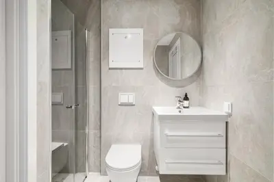 a bathroom with a toilet and a sink and a mirror at BRAND NEW! Bergen Beds Apartments I Cozy Corner in Bergen