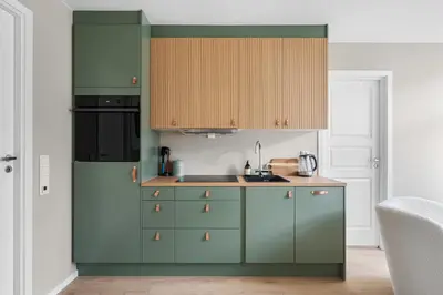 a kitchen with green cabinets and a sink at BRAND NEW! Bergen Beds Apartments I Cozy Corner in Bergen