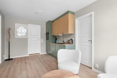 a kitchen with a white chair and a table at BRAND NEW! Bergen Beds Apartments I Cozy Corner in Bergen