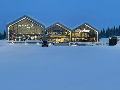 a large building in the snow with the lights on at Skeitunet in Svingvoll