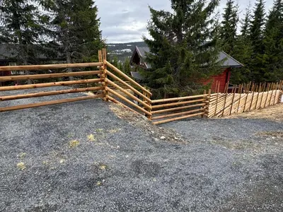a wooden fence in front of a barn at Skeitunet in Svingvoll