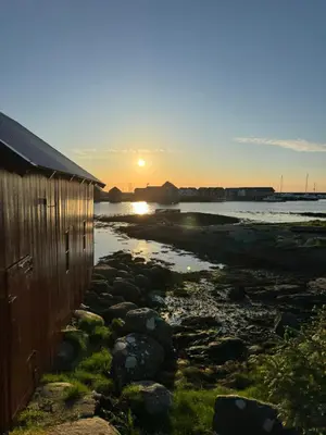 a house on the beach with the sunset in the background at Leilighet på Harøya in Ålesund