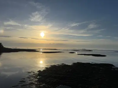 a sun setting over a body of water at Leilighet på Harøya in Ålesund
