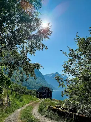 a house on a hill next to a dirt road at Flo Lake House in Stryn