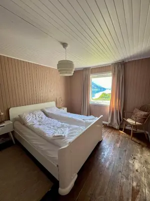 a bedroom with a white bed in a room with a window at Flo Lake House in Stryn