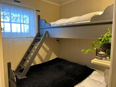 a room with two bunk beds and a staircase at Gvelvåsen Panorama, Blefjell, family cabin with view and nature in Flesberg