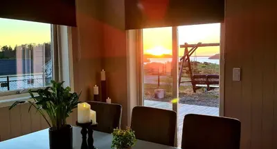 a dining room table with a view of the ocean at Home in Sylta