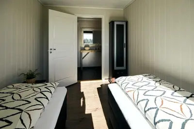 a bedroom with two beds in a room with a door at Home in Sylta