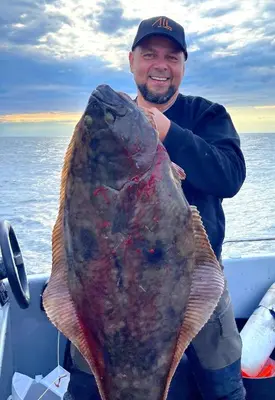 a man holding a large fish in a boat at Home in Sylta