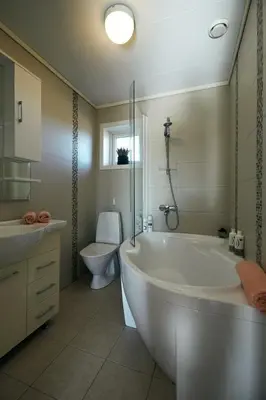 a bathroom with a tub and a toilet and a sink at Home in Sylta