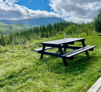 a picnic table sitting on top of a field at 3 Bedroom Apartment with nice view by Gaustatoppen in Gaustablikk