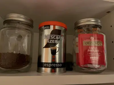 a shelf with three jars of spices and a can of coffee at Leilighet i Lillehammer med gratis parkering in Lillehammer