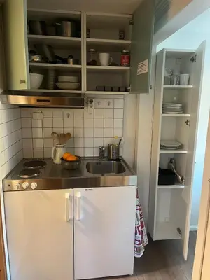 a small kitchen with white cabinets and a sink at Leilighet i Lillehammer med gratis parkering in Lillehammer