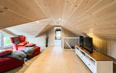 a living room with a red couch and a tv at Stunning Home In Sjusjøen With Sauna in Sjusjøen