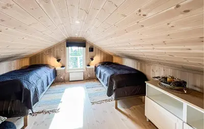 two beds in a room with wooden walls at Stunning Home In Sjusjøen With Sauna in Sjusjøen