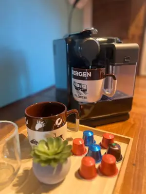 a table with a coffee maker and a cup and a plant at Cozy apartment in City Center in Bergen