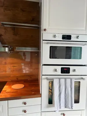 a kitchen with white appliances and a wooden floor at Cozy apartment in City Center in Bergen