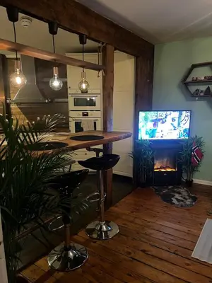 a kitchen with a table and a television and a fireplace at Cozy apartment in City Center in Bergen