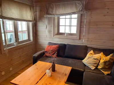 a living room with a couch and a wooden table at Syndinstøga in Ryfoss