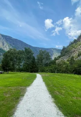a gravel road in a field with mountains in the background at Flåm Retreat in Aurland