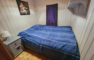 a small bedroom with a bed with a blue comforter at 4 Bedroom Amazing Home In Rødberg in Rødberg