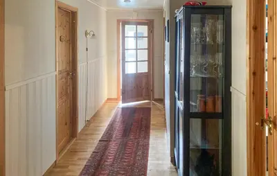 a hallway with a door and a rug on the floor at 4 Bedroom Nice Home In Flornes in Flornes