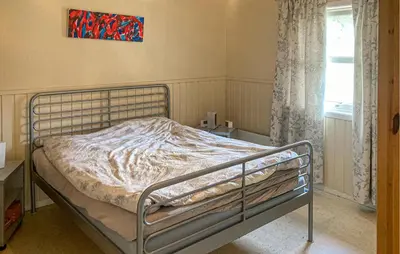 a bed in a bedroom with a painting on the wall at 4 Bedroom Nice Home In Flornes in Flornes
