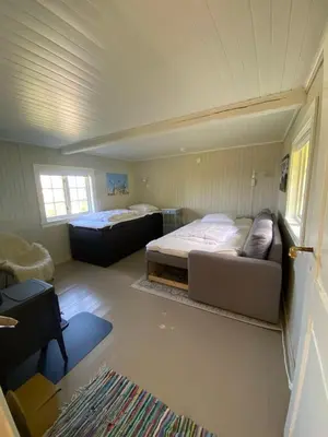 a room with two beds and a couch in it at Lite hus i hagen in Malvik