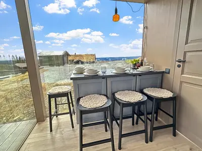 a kitchen with a table with four chairs and a window at Spegill Escape to Mirror Glass and Breathtaking Calm at 1000m in Aurdal
