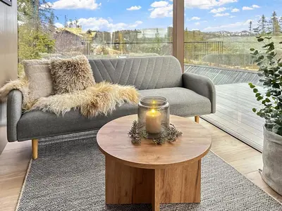 a living room with a couch and a candle on a table at Spegill Escape to Mirror Glass and Breathtaking Calm at 1000m in Aurdal