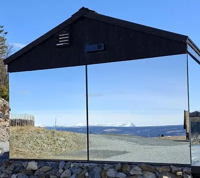 a building with large doors on the side of a road at Spegill Escape to Mirror Glass and Breathtaking Calm at 1000m in Aurdal