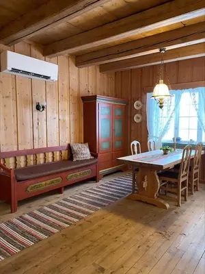 a dining room with a bench and a table in a room at Koselig tømmerhus på gammel gård i Skåbu in Graupe