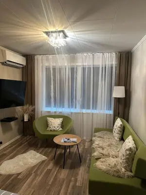 a living room with a green couch and a table at Maria apartment with Sauna Otta in Otta
