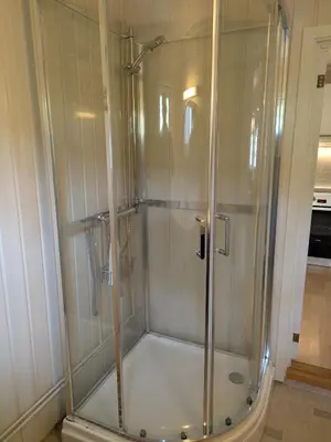 a shower with a glass door in a bathroom at Myrland Apartments in Hovet