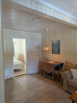 a living room with a table and a bed at Myrland Apartments in Hovet