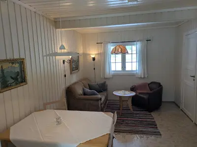 a living room with two chairs and a table at Myrland Apartments in Hovet