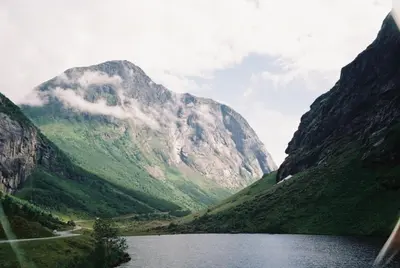 a mountain with a lake in front of it at Near-Sea Boat House With Panoramic Views in Sykkylven