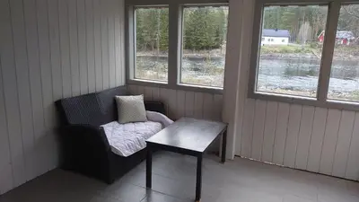 a room with a chair and a table and windows at Studio apartment 48m2 in Hølera